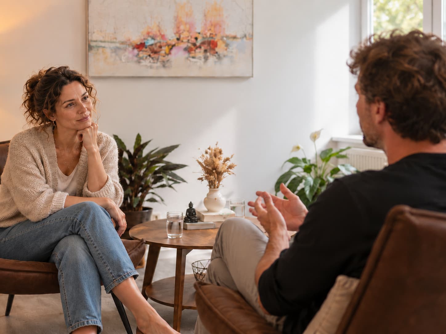 Einzelcoaching als Sinnbild: Eine Frau hört mit aufgestütztem Kinn zu, ihr gegenüber spricht eine Person und gestikuliert